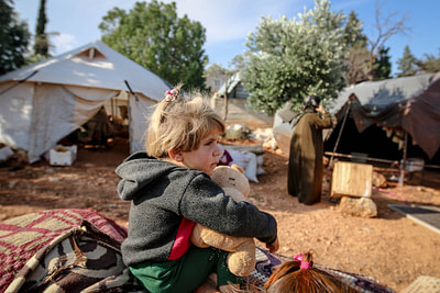 cute girl with toy in refugee camp
