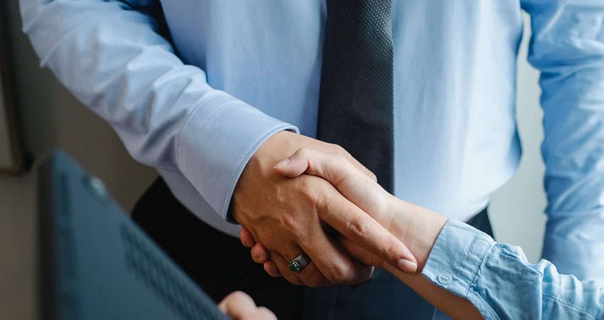 anonymous colleagues shaking hands before business meeting